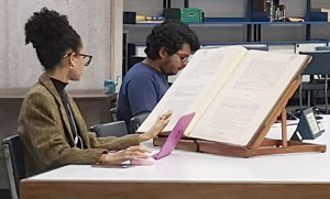 Foto de mujer joven revisando un libro antiguo