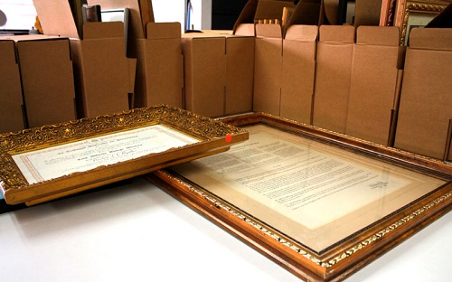 Foto de documentos enmarcados y cajas sobre una mesa