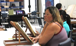 Foto de señora revisando documento en la Sala de Consulta