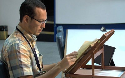 Foto de hombre revisando documento antiguo. Con enlace a Consulta de documentos