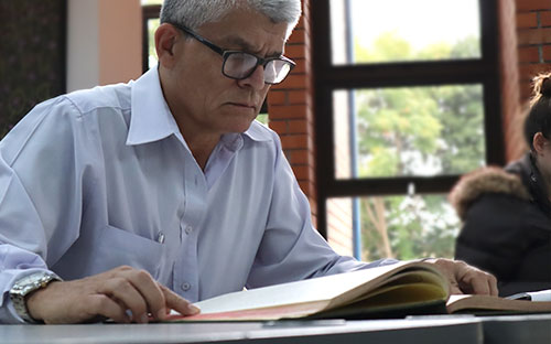 Foto de señor revisando documento dentro del edificio de Archivo Notarial